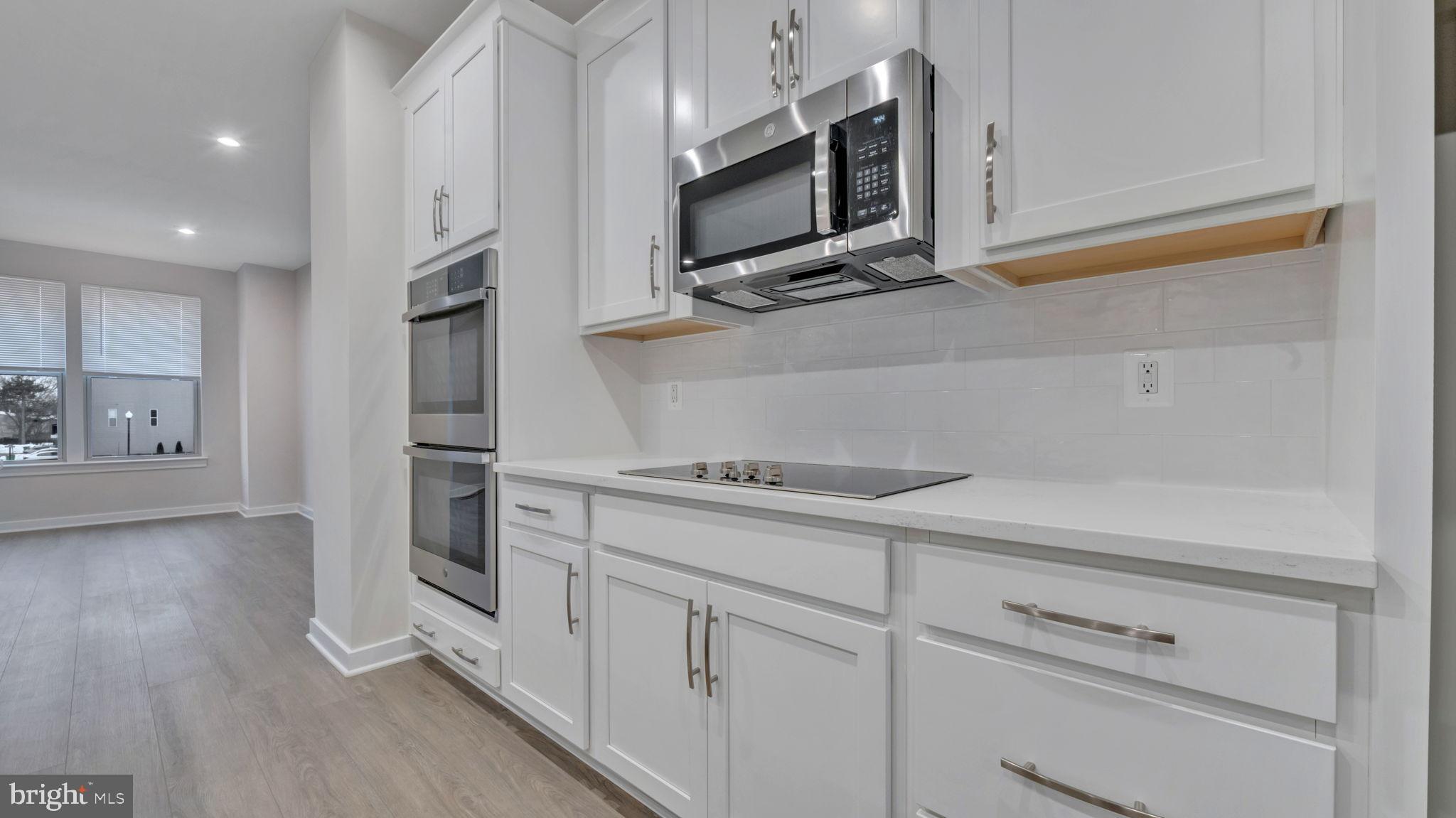 13170 Arches Road Herndon, VA 20170 - Photo 18 of 30 a kitchen with stainless steel appliances white cabinets and wooden floor