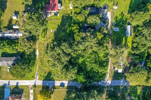 an aerial view of residential house with outdoor space and trees all around