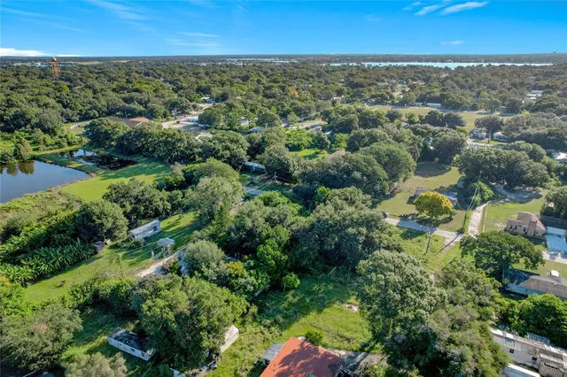 an aerial view of residential houses with outdoor space and trees