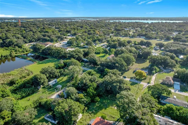 an aerial view of residential houses with city and green space