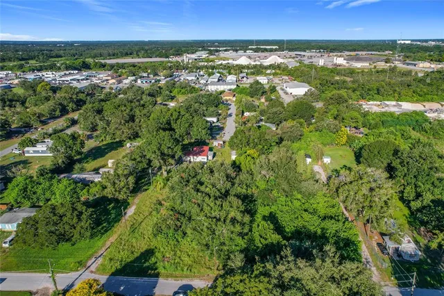an aerial view of residential houses with outdoor space and trees