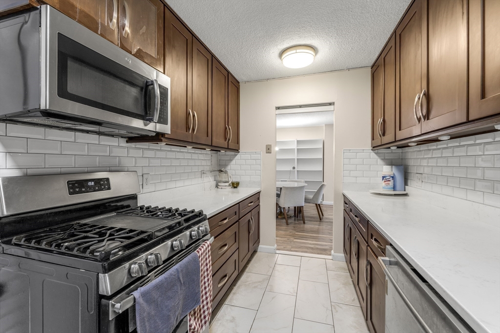 33 Pond Avenue, Unit 919 Brookline, MA 02445 - Photo 14 of 37 a kitchen with stainless steel appliances a sink stove and cabinets