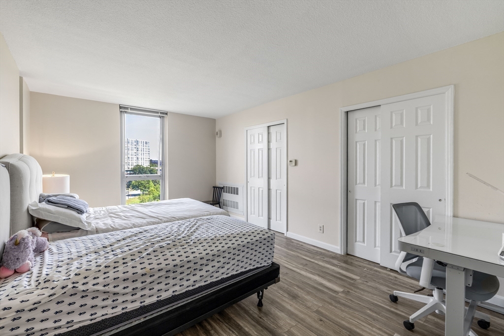 33 Pond Avenue, Unit 919 Brookline, MA 02445 - Photo 15 of 37 a bedroom with a bed a chair and a large window
