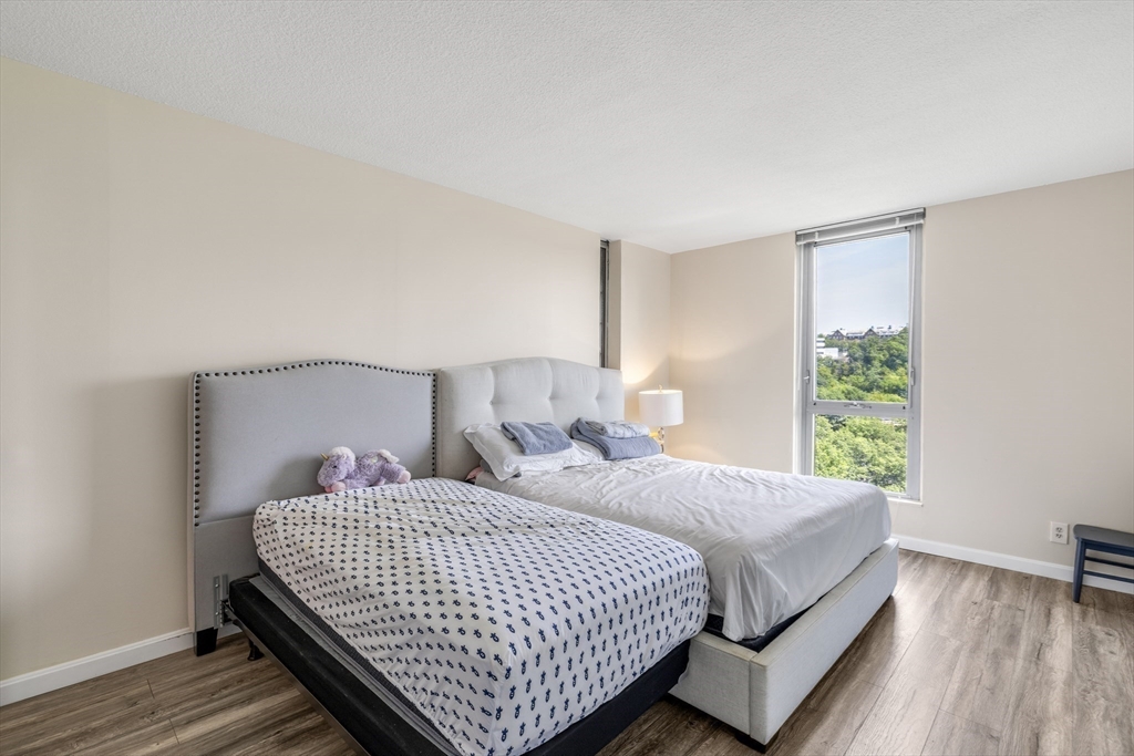 33 Pond Avenue, Unit 919 Brookline, MA 02445 - Photo 17 of 37 a bedroom with a bed and wooden floor