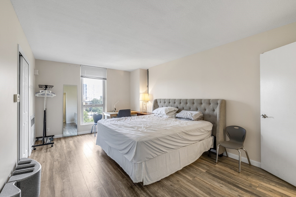 33 Pond Avenue, Unit 919 Brookline, MA 02445 - Photo 20 of 37 a spacious bedroom with a bed and wooden floor
