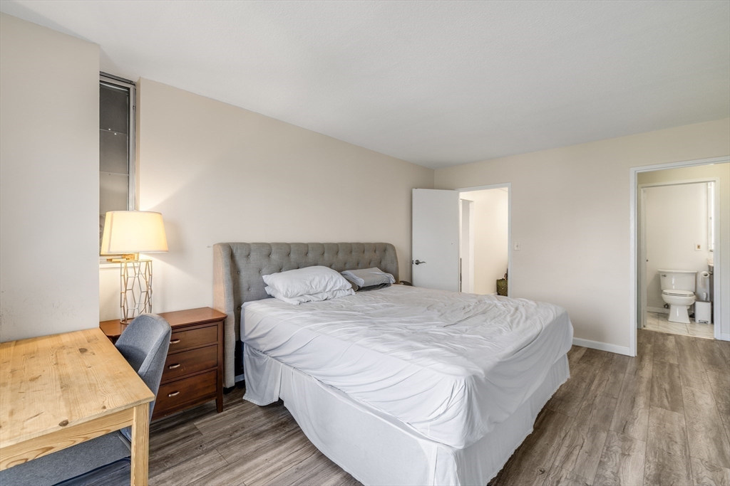 33 Pond Avenue, Unit 919 Brookline, MA 02445 - Photo 21 of 37 a bedroom with a bed and a lamp on table