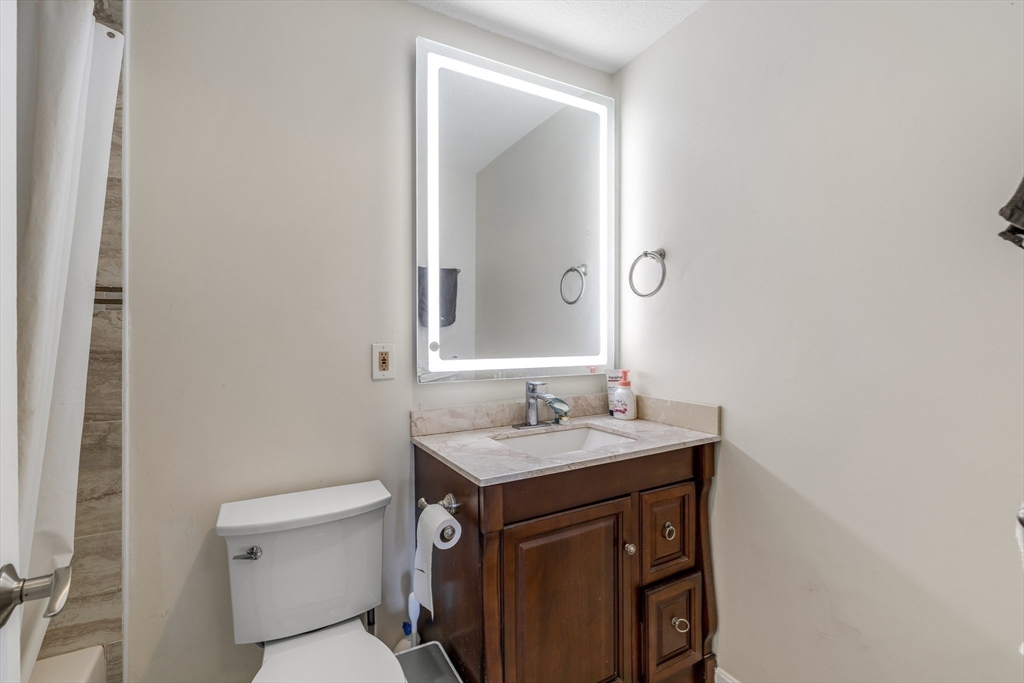 33 Pond Avenue, Unit 919 Brookline, MA 02445 - Photo 23 of 37 a bathroom with a sink toilet vanity and mirror