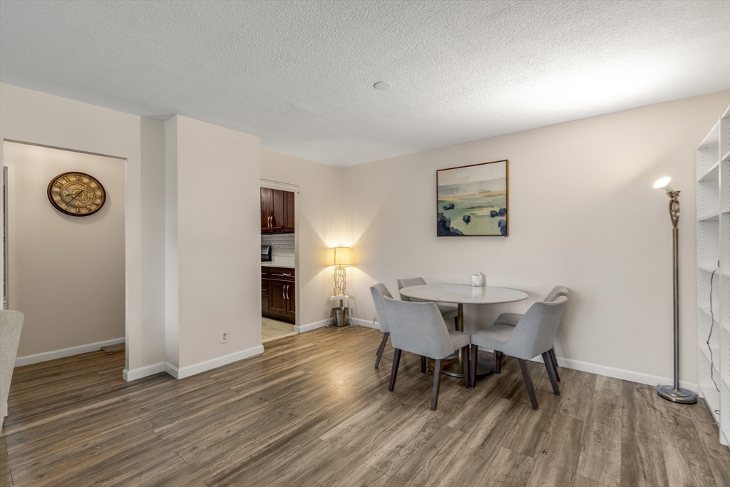 33 Pond Avenue, Unit 919 Brookline, MA 02445 - Photo 9 of 37 a view of a dining room with furniture and wooden floor