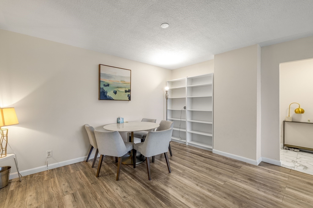 33 Pond Avenue, Unit 919 Brookline, MA 02445 - Photo 10 of 37 a view of a dining room with furniture and wooden floor
