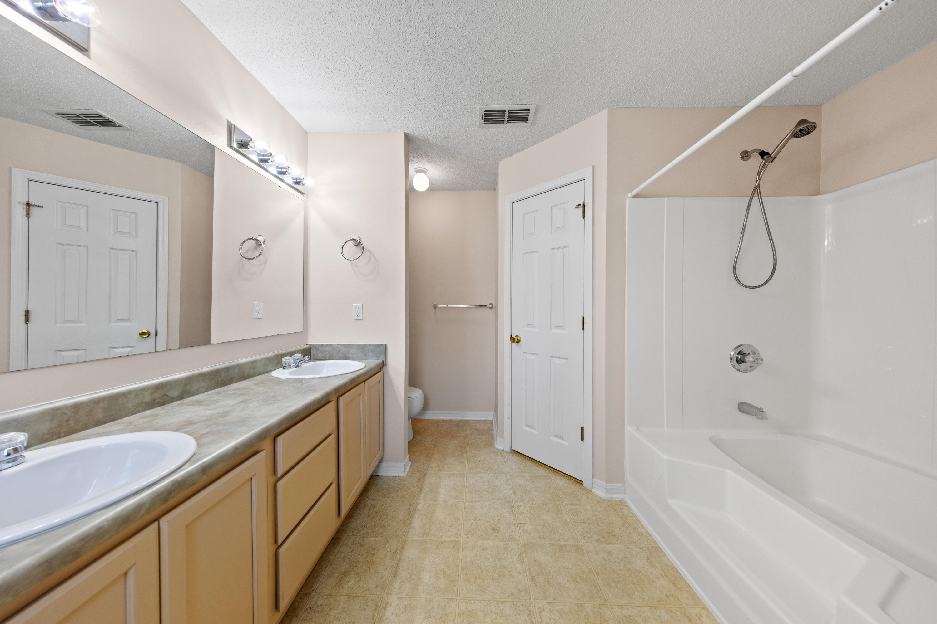 275 Limestone Circle Crestview, FL 32539 - Photo 33 of 45 a bathroom with a granite countertop sink a mirror a bathtub and shower