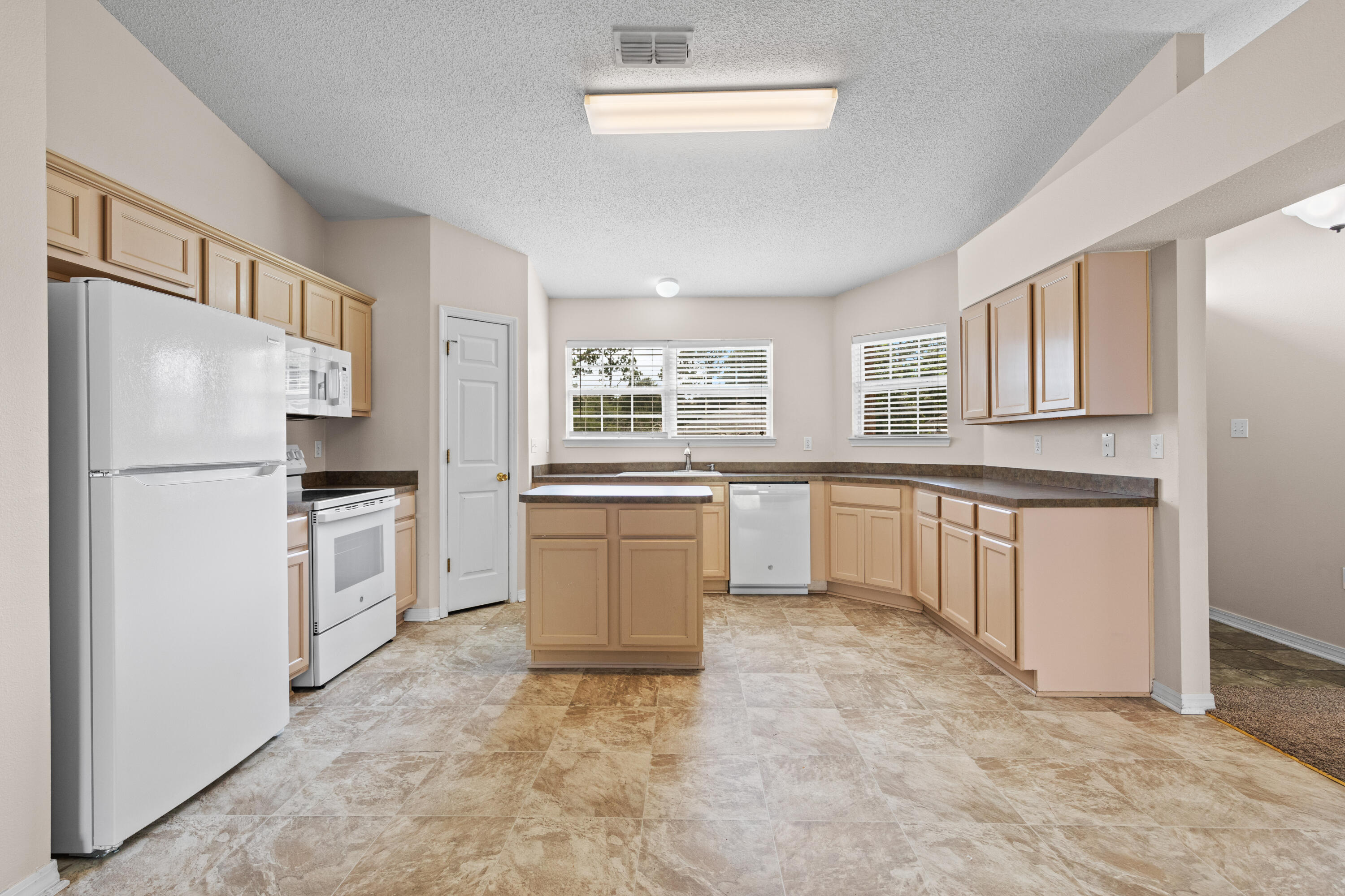 275 Limestone Circle Crestview, FL 32539 - Photo 8 of 45 a kitchen with white cabinets and white appliances