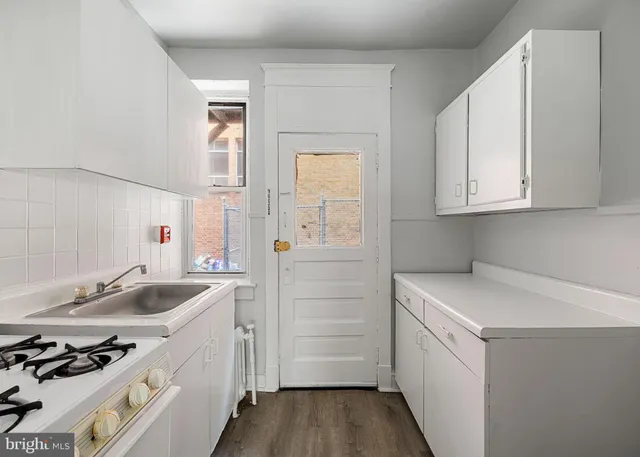 a kitchen that has a sink cabinets and appliances