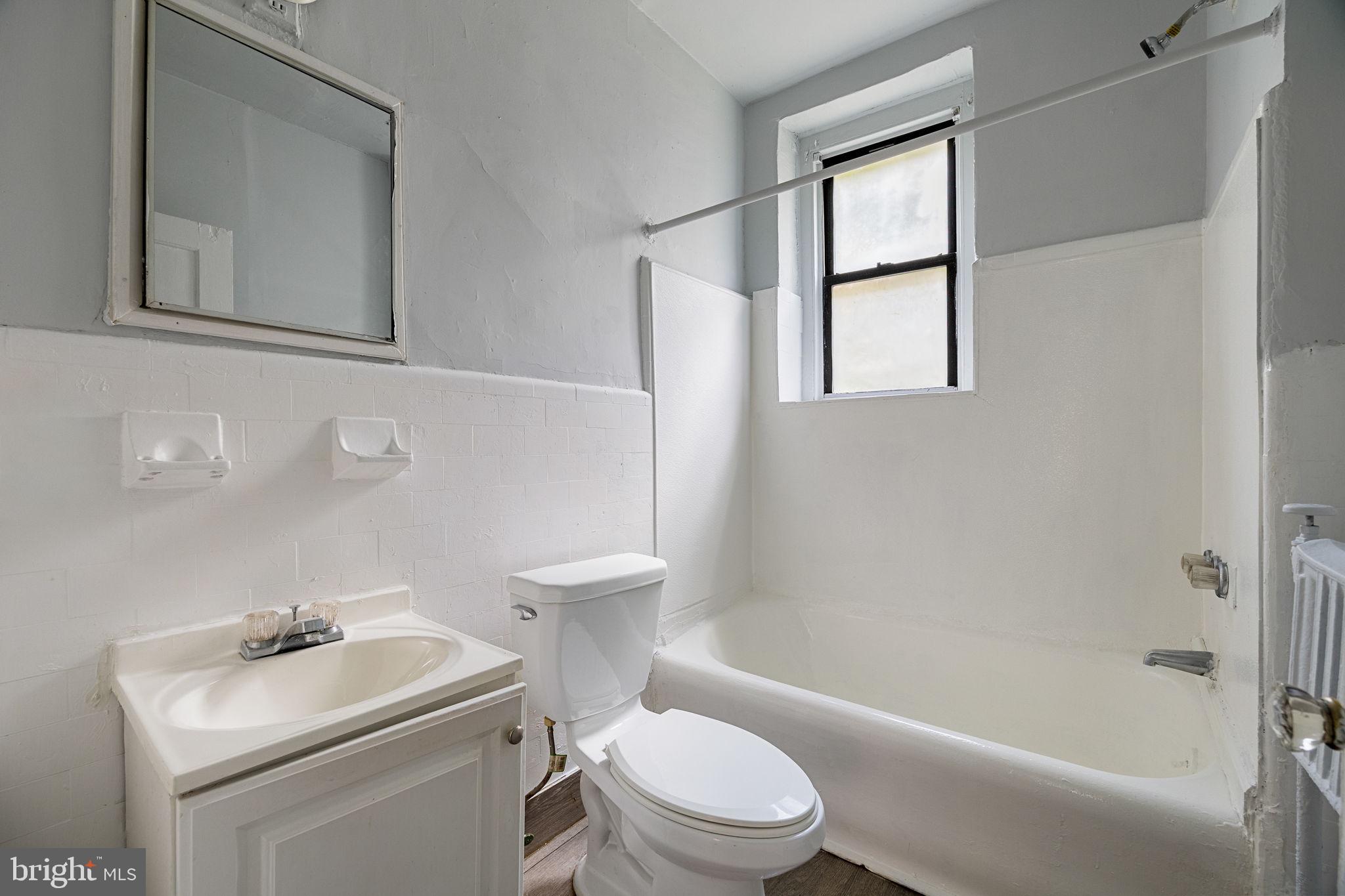 0 Garrett Road, Unit E101 Upper Darby, PA 19082 - Photo 15 of 19 a white toilet sitting next to a bath tub