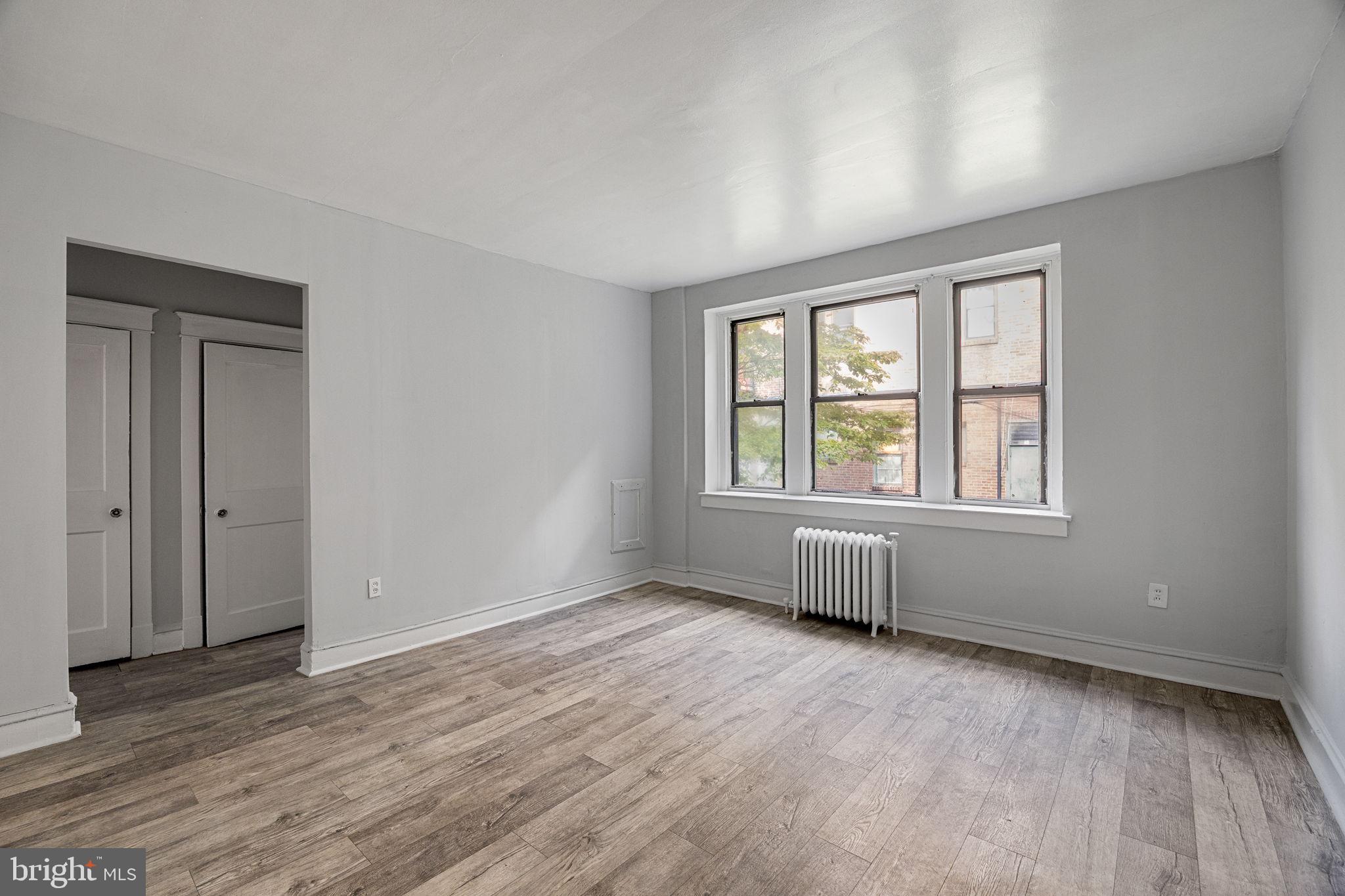 0 Garrett Road, Unit E101 Upper Darby, PA 19082 - Photo 7 of 19 an empty room with wooden floor and windows