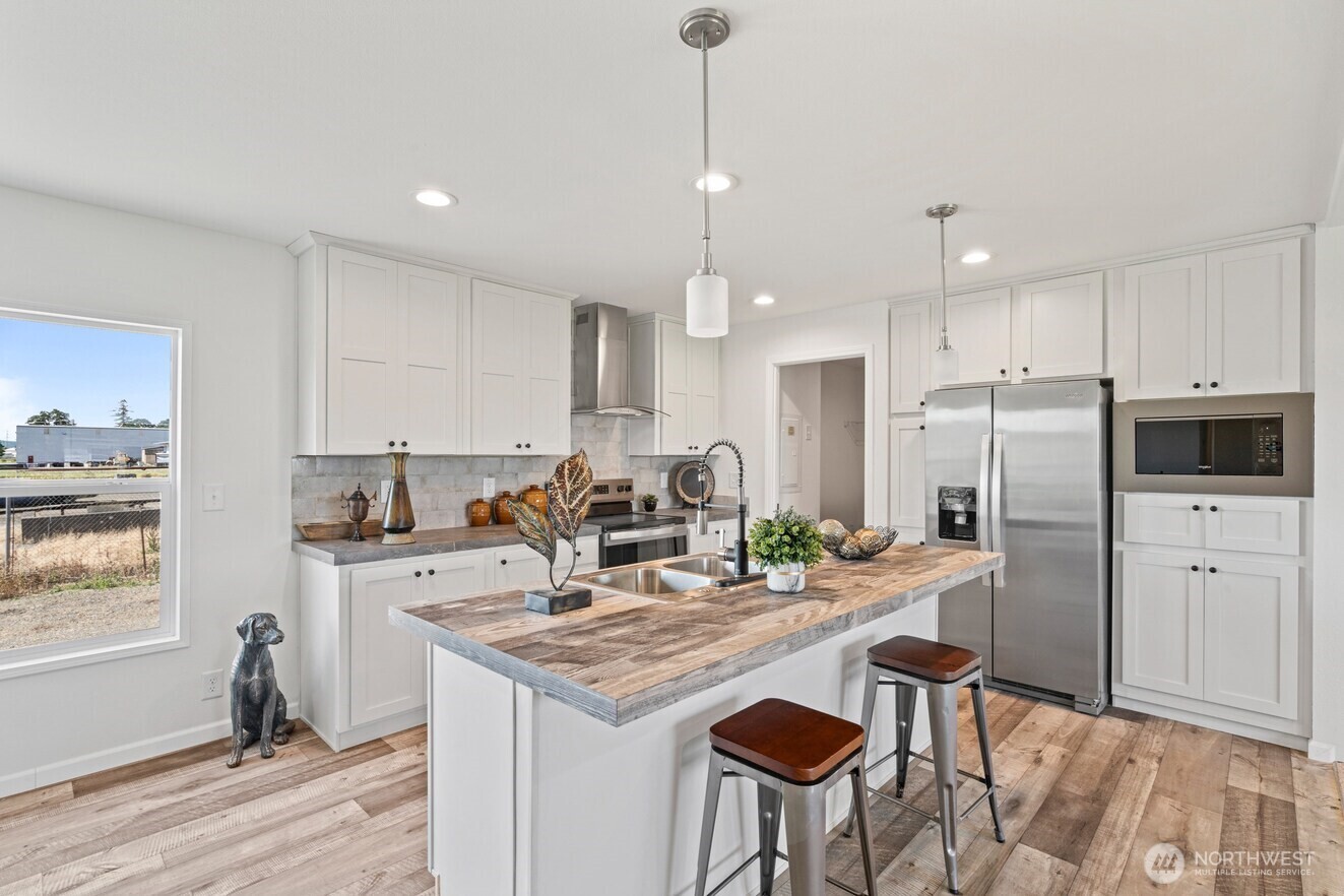 30 Porter Creek Road Elma, WA 98541 - Photo 11 of 12 a kitchen with kitchen island granite countertop a sink stove and refrigerator