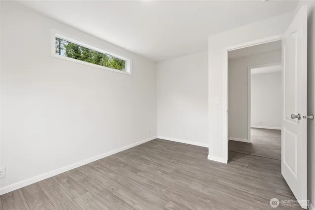 a view of an empty room with wooden floor