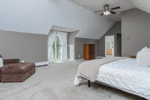 a spacious bedroom with a bed and a chandelier