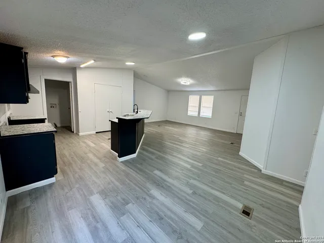 a view of a big room with wooden floor and a window