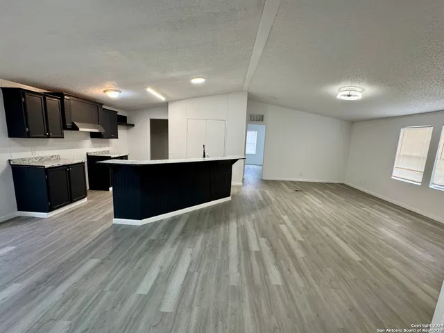 a view of kitchen with wooden floor and electronic appliances