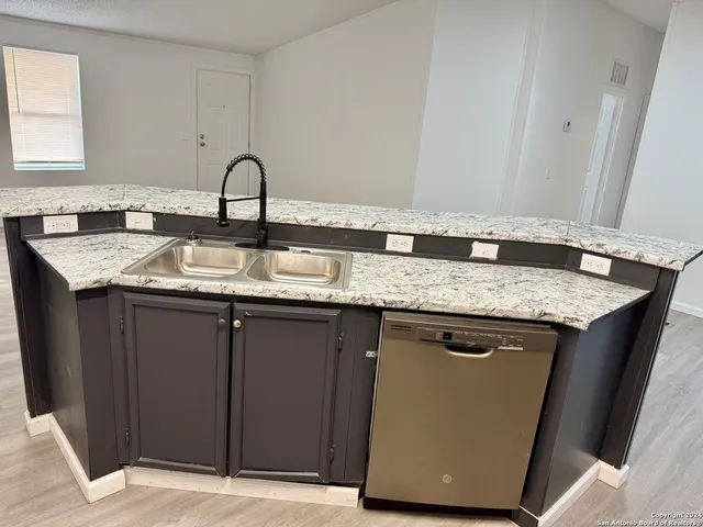 a view of a sink a mirror and cabinets
