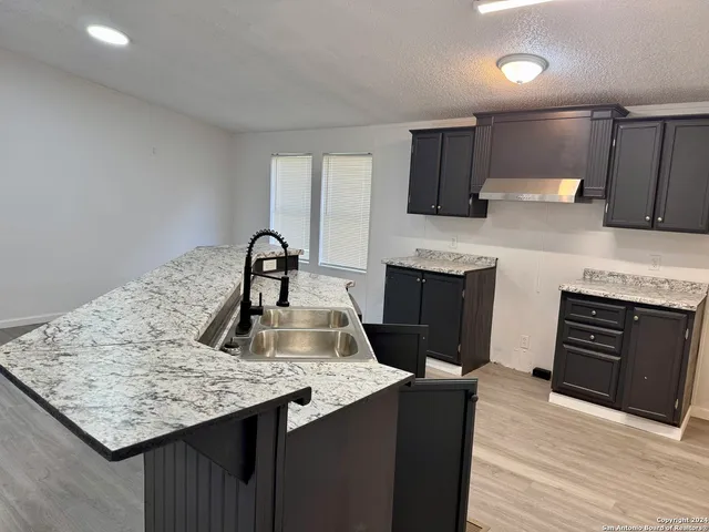a kitchen with granite countertop a refrigerator and a stove