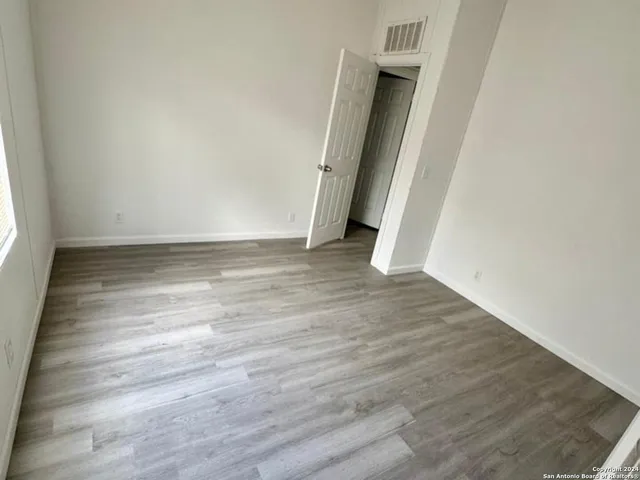 an empty room with wooden floor and entrance