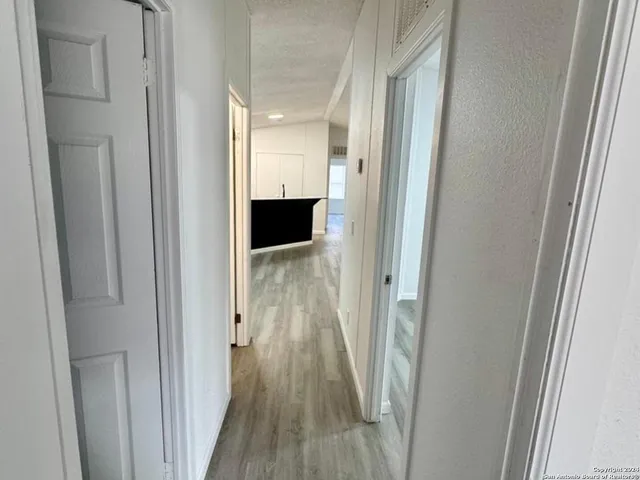 a view of a hallway with wooden floor