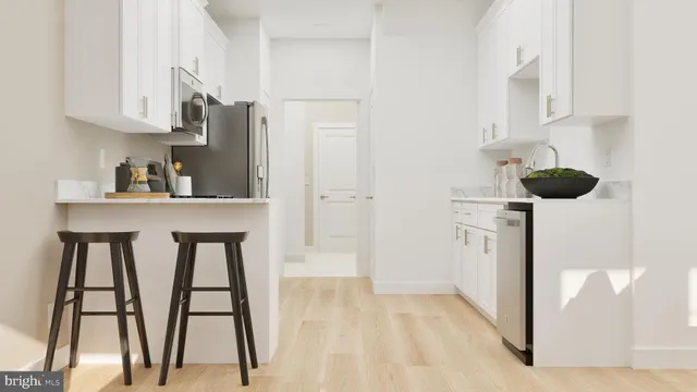 a kitchen with stainless steel appliances kitchen island granite countertop a refrigerator a stove and white cabinets