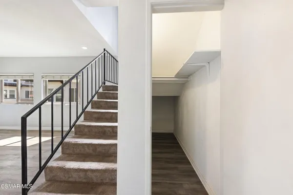 a view of staircase with wooden floor and white walls