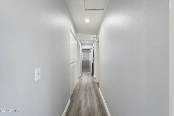 a view of a hallway with wooden floor