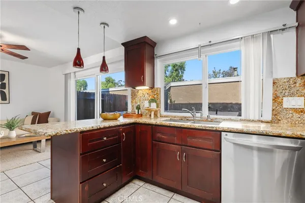 a room with granite countertop a sink and a wooden floor