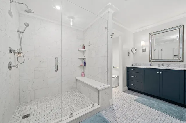 a bathroom with a granite countertop sink a mirror a shower and a bathtub