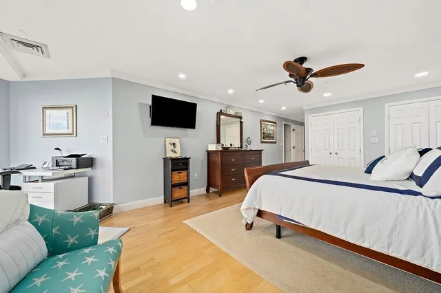 a spacious bedroom with a bed and a flat screen tv