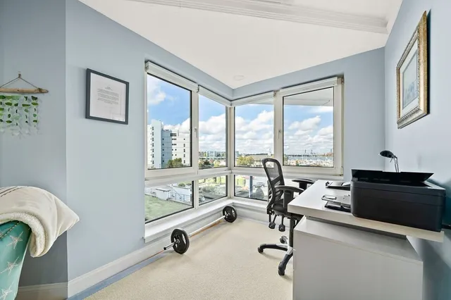 a view of a livingroom with workspace and a large window