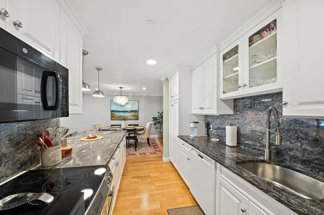 a kitchen with stainless steel appliances granite countertop a sink stove and cabinets
