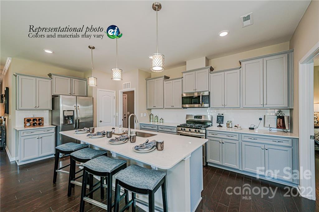 5777 Soft Shell Drive, Unit 309 Lancaster, SC 29720 - Photo 5 of 21 a kitchen with refrigerator cabinets and a center island