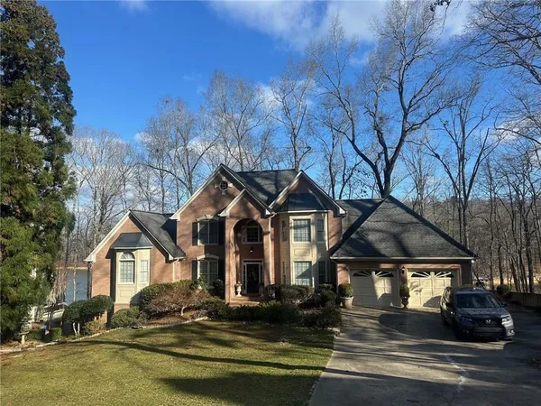 a front view of a house with a yard and balcony