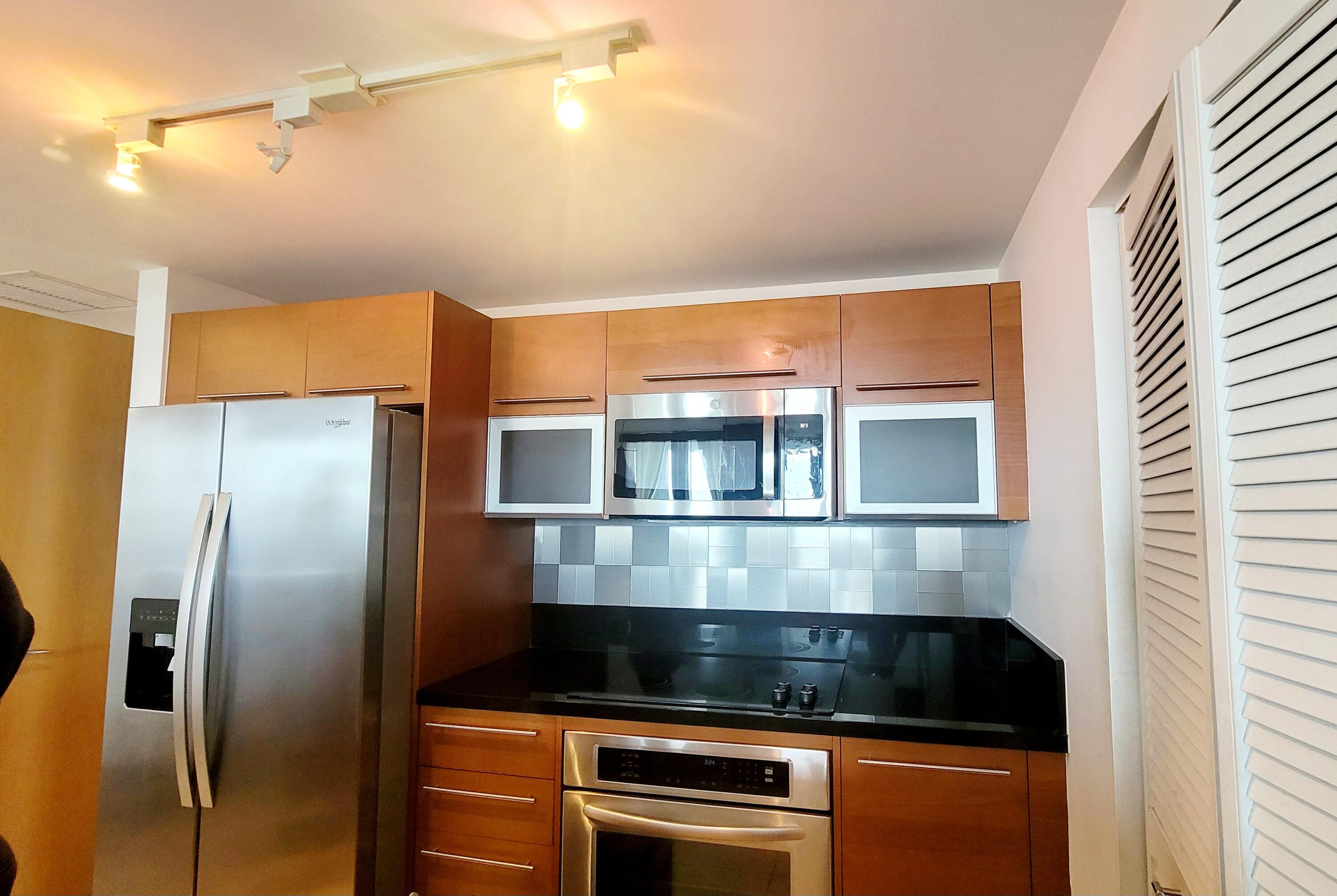 244 Biscayne Boulevard, Unit 401 Miami, FL 33132 - Photo 11 of 36 a kitchen with stainless steel appliances granite countertop a refrigerator and a stove