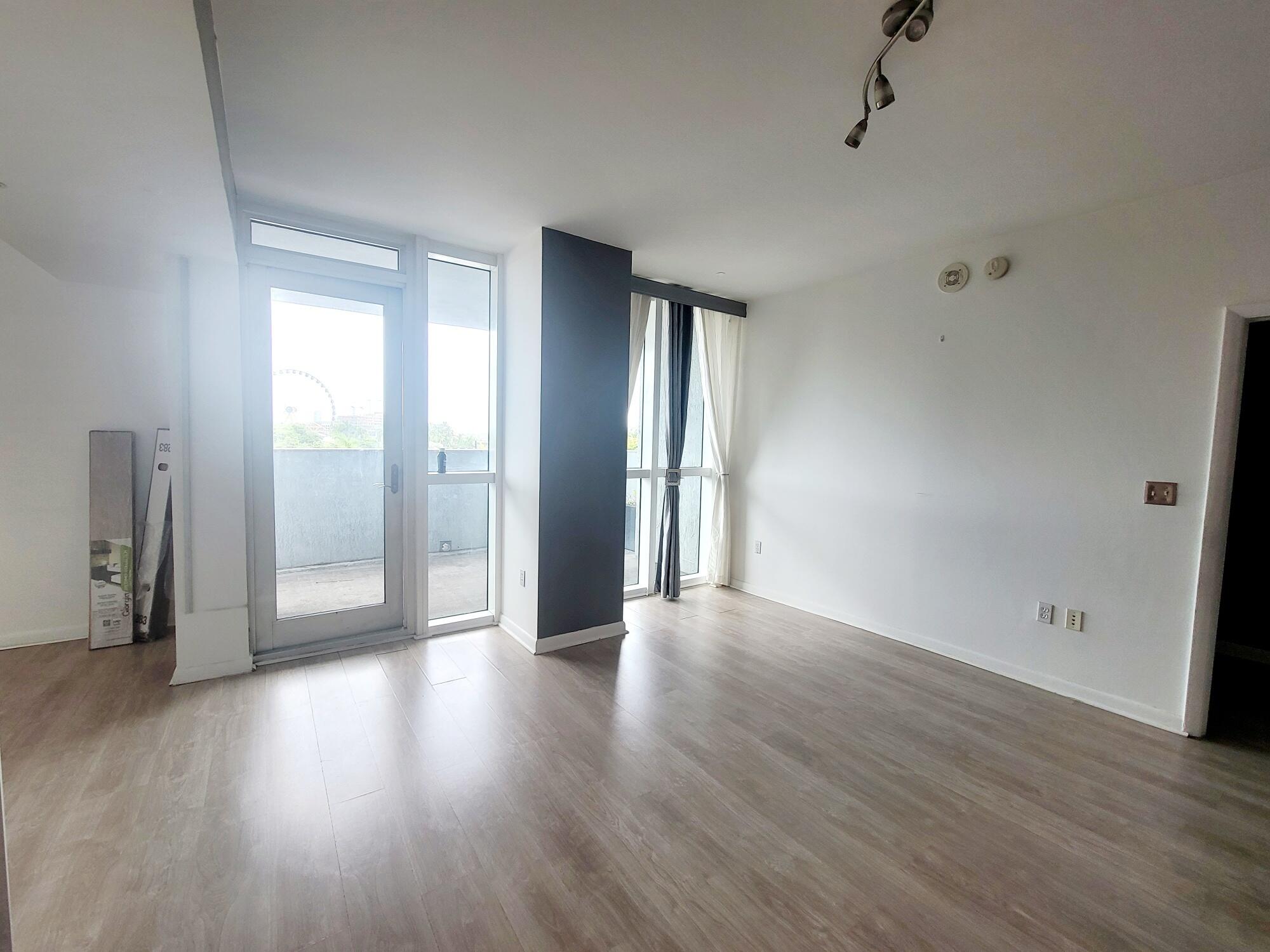 244 Biscayne Boulevard, Unit 401 Miami, FL 33132 - Photo 13 of 36 a view of an empty room with wooden floor and a window