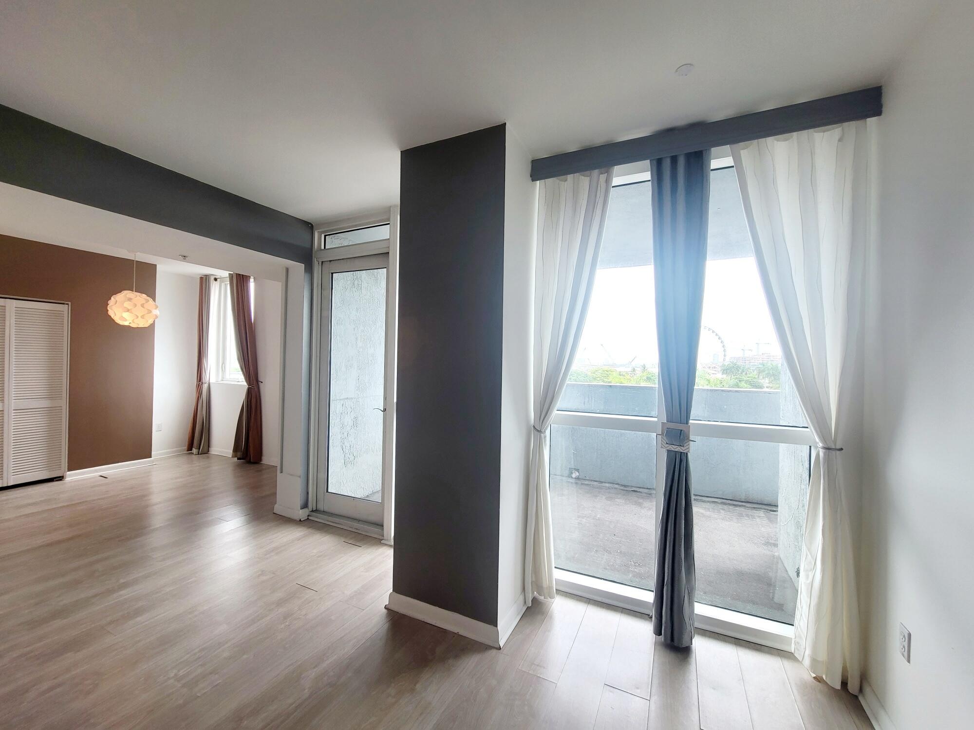 244 Biscayne Boulevard, Unit 401 Miami, FL 33132 - Photo 14 of 36 a view of an empty room with wooden floor and a window