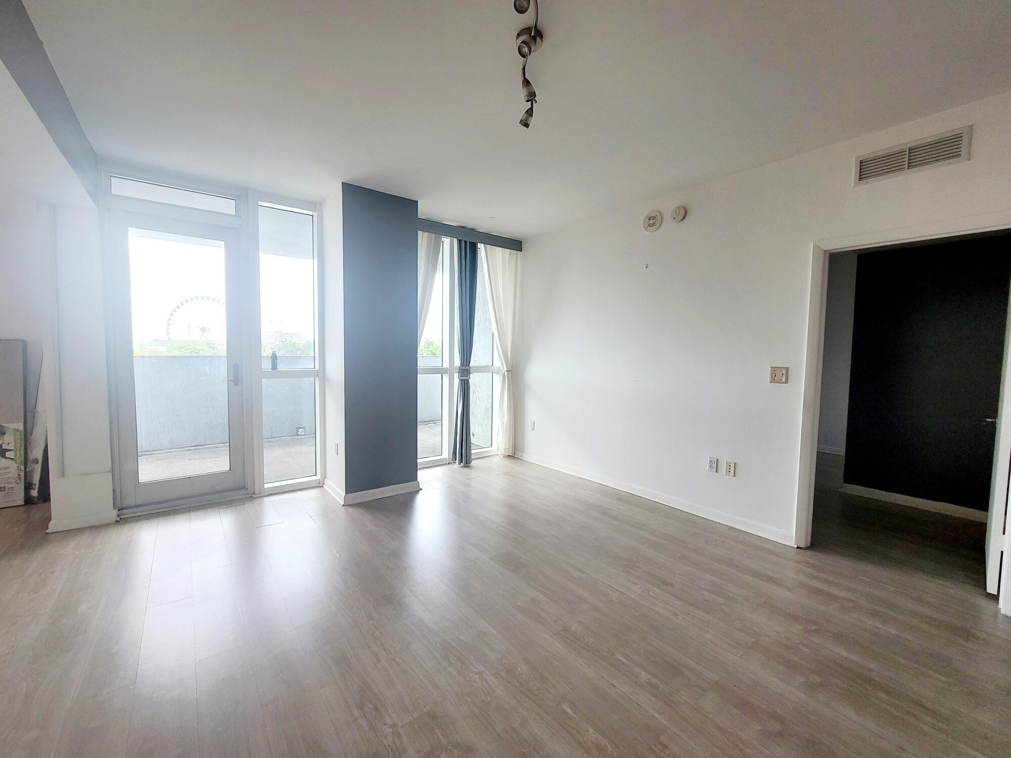 244 Biscayne Boulevard, Unit 401 Miami, FL 33132 - Photo 23 of 36 a view of an empty room with wooden floor and a window