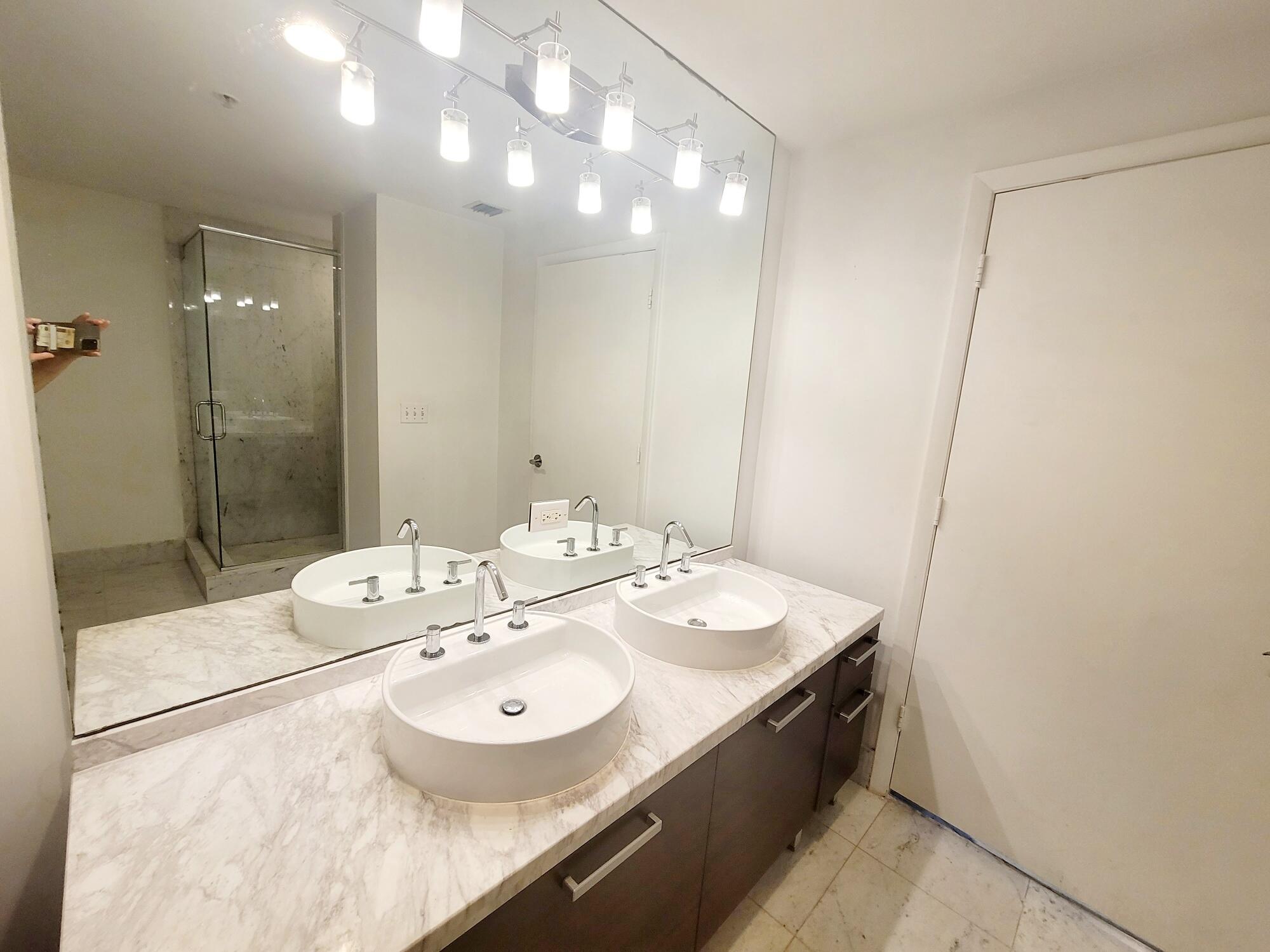 244 Biscayne Boulevard, Unit 401 Miami, FL 33132 - Photo 25 of 36 a spacious bathroom with a sink a mirror and a shower