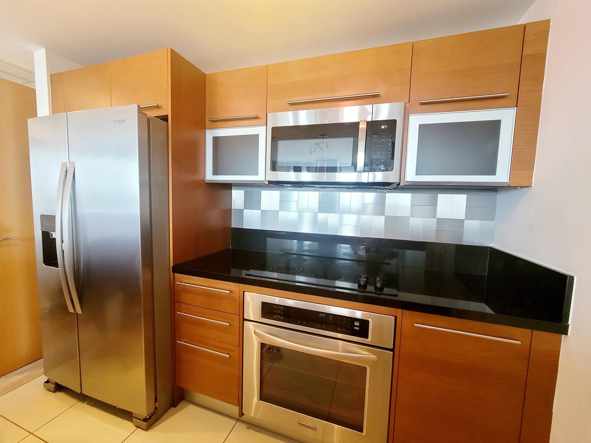 244 Biscayne Boulevard, Unit 401 Miami, FL 33132 - Photo 9 of 36 a kitchen with granite countertop a refrigerator and a sink