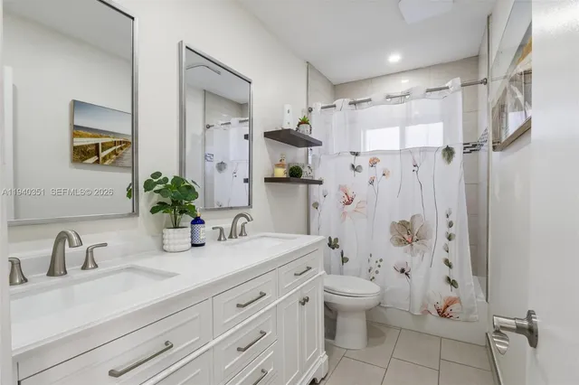 a bathroom with a double vanity sink toilet and shower