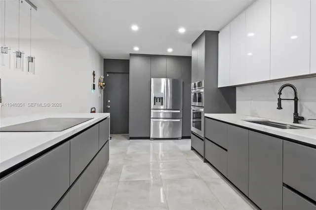a large kitchen with a sink and stainless steel appliances