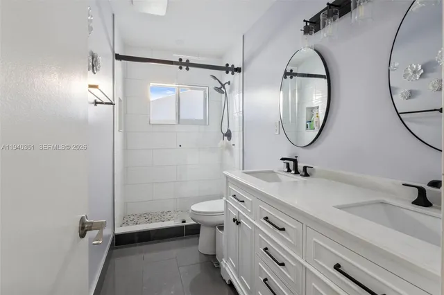 a bathroom with a granite countertop sink mirror toilet and shower