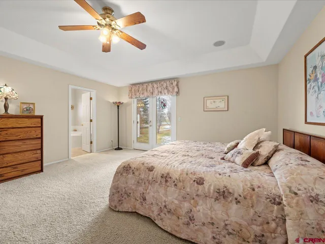 a bedroom with a bed chandelier and a window