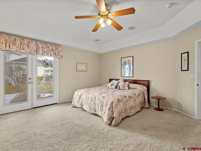 a spacious bedroom with a bed painting on wall and a large window