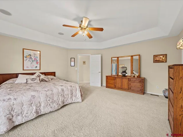 a spacious bedroom with a bed and a chandelier