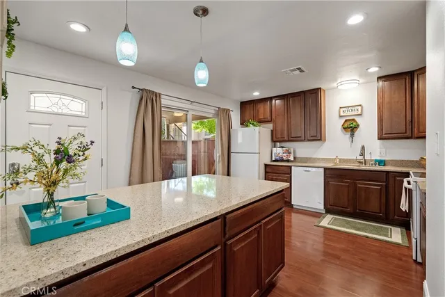 a kitchen with kitchen island granite countertop a sink a counter top space and cabinets